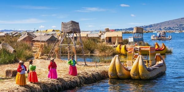 PUNO, PERU - MAY 14, 2015: Unidentified women in traditional dresses welcome tourists in Uros Island.