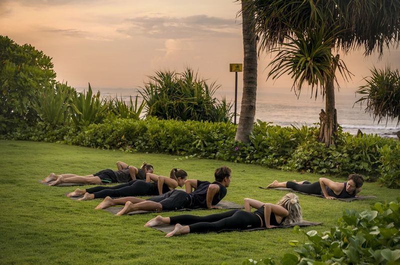 Group practicing yoga at COMO Uma Canggu with the sea in the background