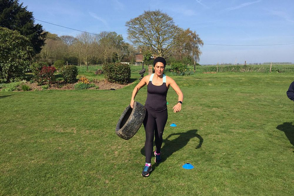 Woman carrying a tyre on a fitness bootcamp in Kent, UK