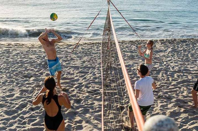 Group of people playing volleyball on the beach