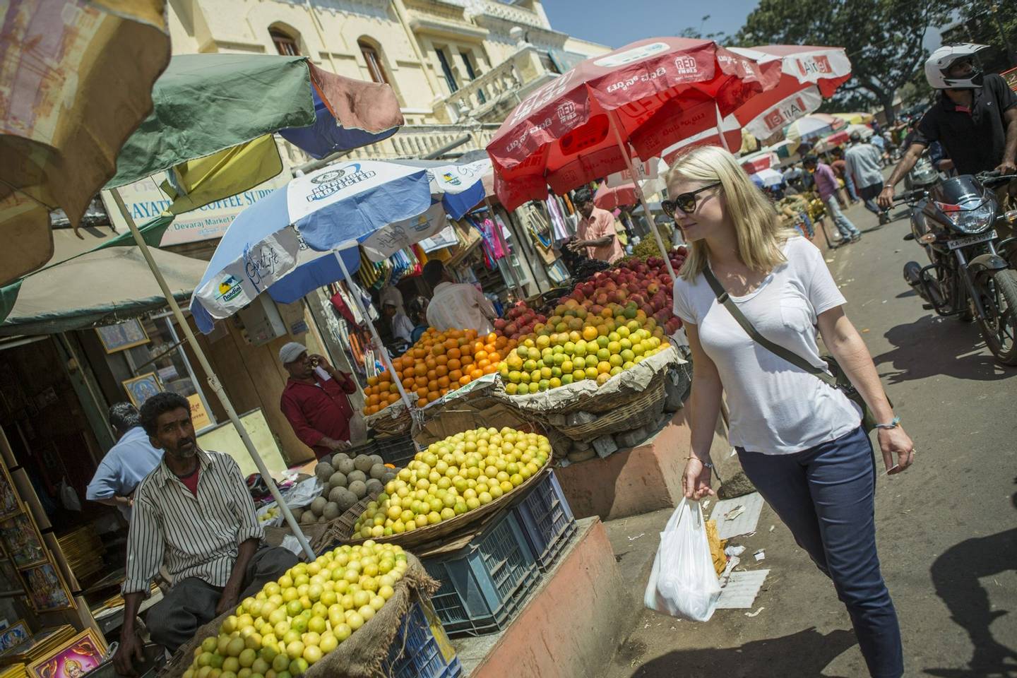 Blonde haired woman walking in an Indian market